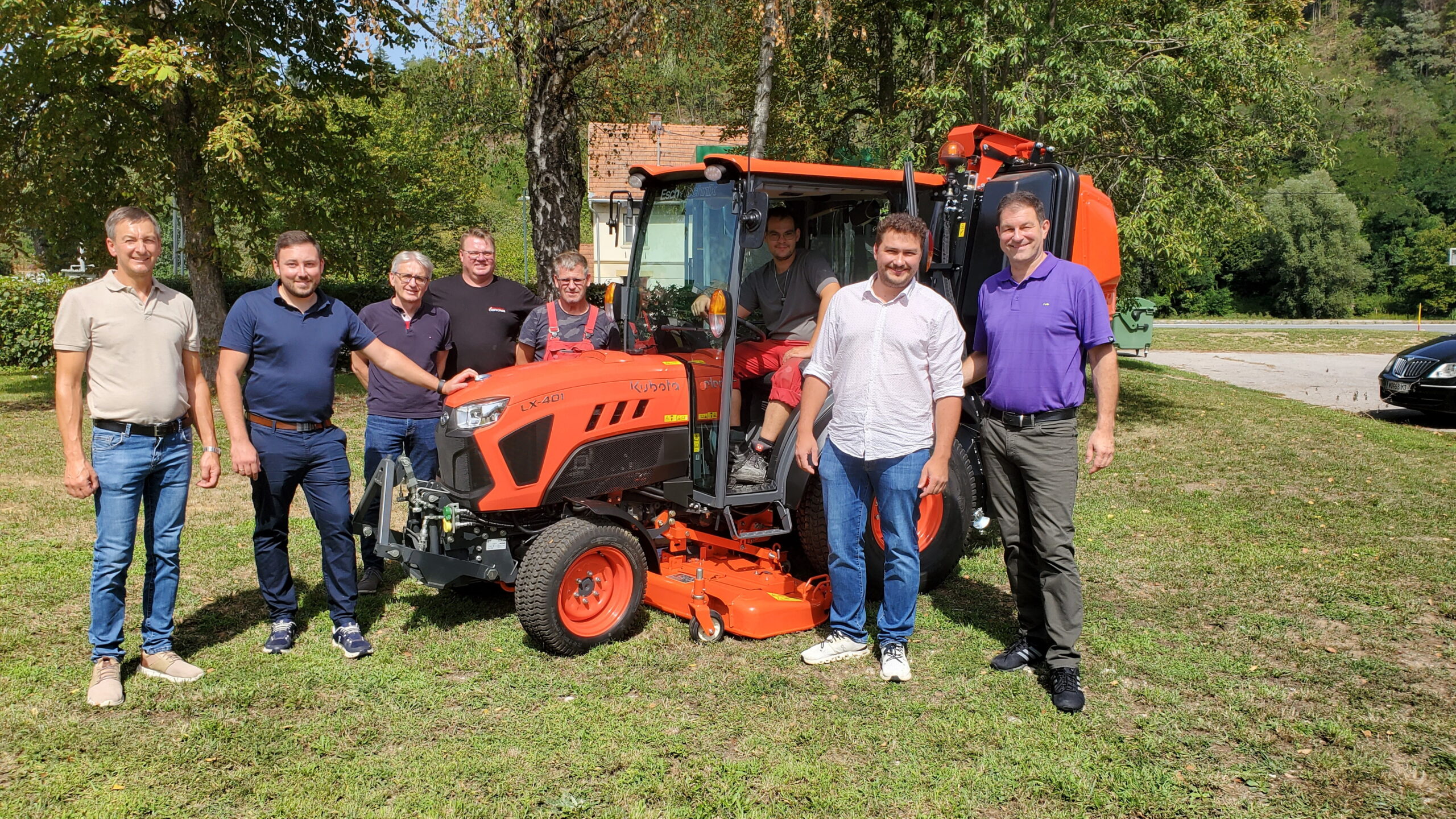 Kubota LX-401 Traktor mit acht Männern in Österreich, darunter Josef Schwaiger, Bürgermeister von St. Veit, und Vizebürgermeister Christian Haidinger.
